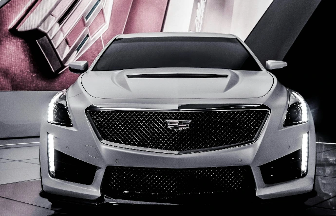 a white cadillac parked in front of a wall